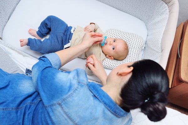 Baby in crib with mom looking over the side